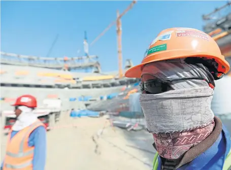  ?? Picture Ali Haider ?? Constructi­on workers help to build the World Cup venue at Lusail Stadium in Doha, Qatar