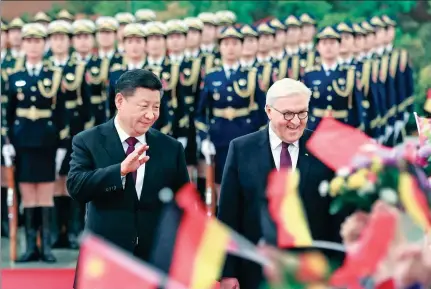  ?? PANG XINGLEI / XINHUA ?? President Xi Jinping and German President Frank-Walter Steinmeier interact with children bearing flowers and flags during a welcoming ceremony in the Great Hall of the People in Beijing on Monday.