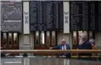  ?? — Reuters ?? Traders stand near stock index boards at Madrid’s bourse.