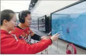  ?? PHOTOS PROVIDED TO CHINA DAILY ?? A China Unicom staff teaches a customer to use his phone to purchase goods displayed on screens.