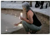  ?? Guy Mccathy
/ Union Democrat ?? About two dozen people took part in a candleligh­t vigil Wednesday evening in Sonora for 19 children and two adults who were gunned down at atexas school. Lauren Hurley, of Jamestown (above), reaches for a candle representi­ng one of 21 victims massacred in the shooting.