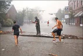  ?? Chris Seward / Associated Press ?? People survey the damage caused by Hurricane Florence on Front Street in downtown New Bern, N.C., on Friday.