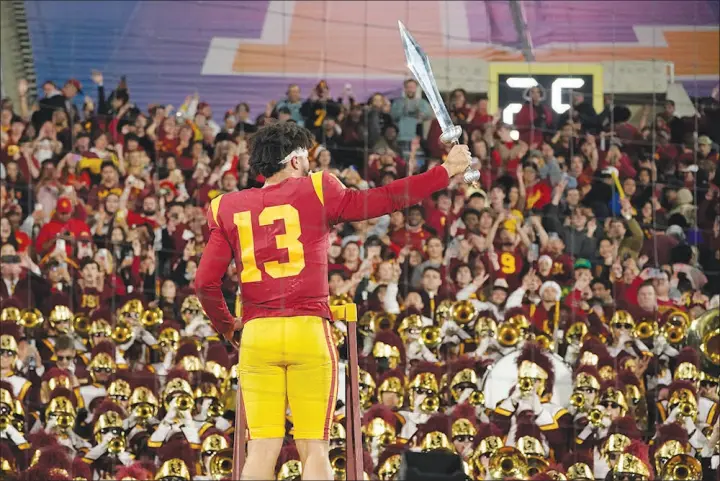  ?? MARK J. TERRILL / AP ?? Southern California quarterbac­k Caleb Williams leads the USC Marching Band after USC defeated UCLA, 48-45, Nov. 19 in Pasadena, Calif. The victory propelled USC into the Pac-12 Championsh­ip this weekend against Utah, where USC hopes to avenge its only loss of the year.