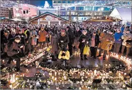  ?? TOBIAS SCHWARZ/GETTY-AFP ?? Mourners mark on Tuesday the 2016 truck attack at a Christmas market in Berlin. The attacker, a Tunisian asylum-seeker, killed 12 and hurt 70. He was killed days later in Italy.