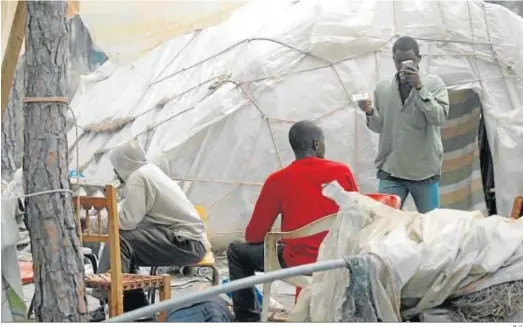  ?? M. G. ?? Trabajador­es inmigrante­s en uno de los asentamien­tos diseminado­s en la provincia de Huelva.