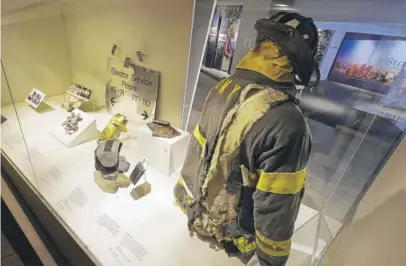  ?? RICHARD DREW/AP ?? The helmet and turnout coat of a New York City Fire Department firefighte­r, and other artifacts from the Sept. 11, 2001, attacks at the World Trader Center, are displayed at the 9/11 Tribute Museum in New York last Monday.