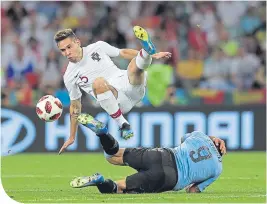  ??  ?? Portugal’s Guerreiro takes to the air in a clash with Sanchez