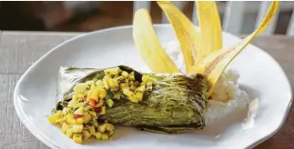  ?? Photos by Melissa Phillip / Staff photograph­er ?? A new Field &amp; Tides menu accompanyi­ng the bar includes the banana leaf fish (fish of the day in banan leaf with curry, garlic and citrus served with mango salsa and fried plantains).