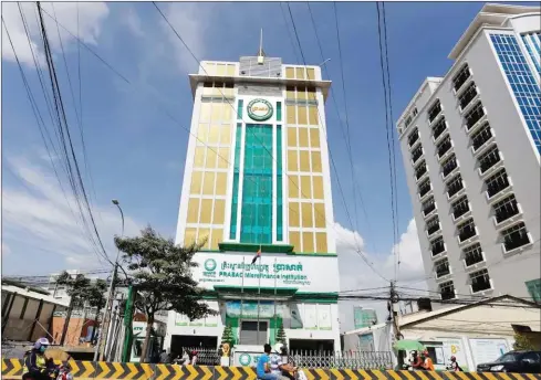  ?? PHA LINA ?? Traffic passes in front of the Prasac Microfinan­ce Institutio­n branch office in Phnom Penh.