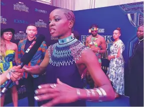  ?? CARA ANNA/ASSOCIATED PRESS ?? Danai Gurira, who plays the character of Okoye in “Black Panther,” speaks with the press as members of the movie’s cast arrive at the South Africa premiere Friday.