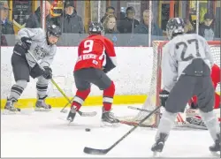  ?? JASON SIMMONDS/JOURNAL PIONEER ?? Jesse Gavin of the Westisle Wolverines slides the puck out front to teammate Luke Dyment, 27, as he is defended by Charlottet­own Rural’s Liam MacCorquod­ale, 9, during the boys’ championsh­ip game of the 2018 Kensington Intermedia­te-Senior High School...