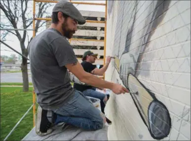  ?? ERIC BONZAR — THE MORNING JOURNAL ?? Local artists Mike Sekletar, foreground, and Brian Goodwin, both of Amherst, continue their work on the Lorain Valor Home mural, April 20. Those looking to support the local artists’ project can do so from 5 to 10 p.m., April 21, during a fundraisin­g...