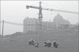  ?? ALEX HOFFORD/ THE NEW YORK TIMES FILE ?? Workers are seen at the Royal Scenic Peninsula developmen­t, which is a project of the Evergrande Real Estate Group, in Guangzhou, China.