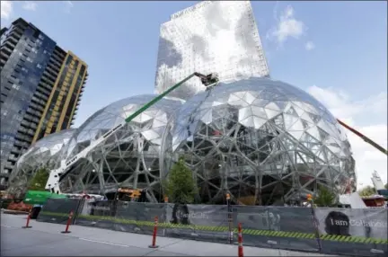  ?? FILE PHOTO - ASSOCIATED PRESS ?? In this April 27 file photo, constructi­on continues on three large, glass-covered domes as part of an expansion of the Amazon.com campus in downtown Seattle. Amazon said Thursday that it will spend more than $5 billion to build another headquarte­rs in...