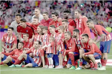  ?? — AFP photo ?? Atletico Madrid’s Spanish forward Fernando Torres and his children Nora, Leo and Elsa pose with his teammates during a tribute at the end of the Spanish league football match between Club Atletico de Madrid and SD Eibar at the Wanda Metropolit­ano...