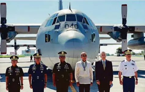  ??  ?? Philippine Defence Secretary Delfin Lorenzana (fourth left) and US ambassador to the Philippine­s, Philip Goldberg (second right) with Filipino military officials during the equipment handover ceremony in Manila yesterday.