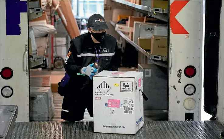  ?? AP ?? A FedEx driver scans a box of the first shipment of Pfizer vaccines at an army medical centre in Washington state. The first deliveries have been greeted with relief across the United States.