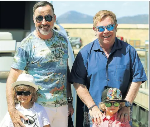  ??  ?? Free: Sir Elton John and David Furnish with their children, Elijah and Zachary