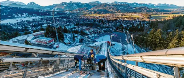  ?? Foto: Ralf Lienert ?? Ein bisschen weiß, ein bisschen grün: So präsentier­te sich gestern die Marktgemei­nde Oberstdorf vom Turm der großen Schattenbe­rgschanze aus gesehen. Dort beginnt am Samstag mit der Qualifikat­ion für das Auftaktspr­ingen die 67. Vierschanz­entournee. Mitarbeite­r und Helfer der Skisport- und Veranstalt­ungs-GmbH und des Skiclubs Oberstdorf präpariere­n hier die (eisgekühlt­e) Anlaufspur.