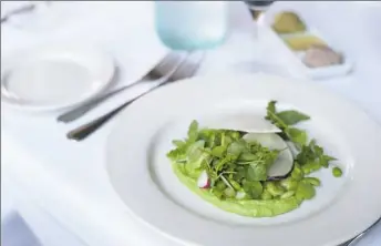  ?? Stephanie Strasburg/Post-Gazette photos ?? The Fava Salad at Lidia’s Pittsburgh is made with fava and lima beans, three types of radish — ‘Easter Egg,’ black and ‘Green Meat’ — watercress and mint. The salad is served on a pool of pea puree and is topped with a thin slice of pecorino.