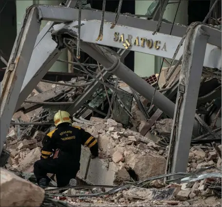  ?? AP ?? TRAGIC: A member of a rescue team searches for survivors at the site of a deadly explosion that destroyed the five-star Hotel Saratoga, in Havana, Cuba, on Friday.