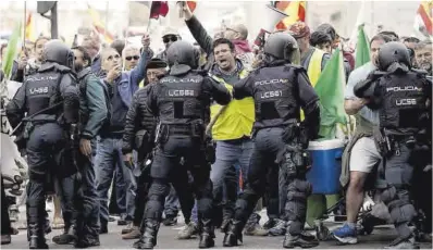  ?? José Luis Roca ?? Varios policías tratan de frenar a los payeses que se manifiesta­n en Madrid, ayer.