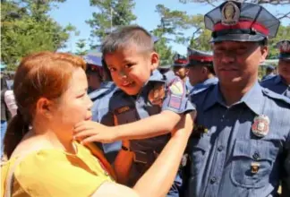  ?? Photo by Milo Brioso ?? NEXT IN LINE. Newly promoted SPO1 Bernardo Corona of the Baguio City Police Office is accompanie­d by son and wife during the donning an dinning of ranks ceremony held at Camp Bado Dangwa on Monday.