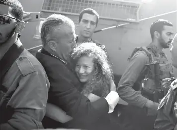  ?? Associated Press ?? ■ Ahed Tamimi is hugged by her father Bassem as she is released from Israeli prison Sunday after serving an eightmonth sentence.