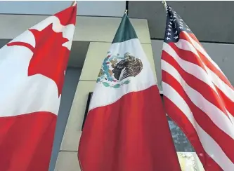  ?? GETTY FILES ?? The flags of Canada, Mexico and the U.S. are seen in the outside the third round of NAFTA renegotiat­ions in September.