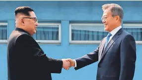  ??  ?? North Korea’s Kim Jong Un, left, and South Korea’s Moon Jae-in meet April 27 at the border that divides their countries. POOL PHOTO FROM AFP/GETTY IMAGES