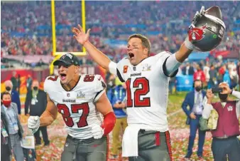  ?? AP PHOTO/STEVE LUCIANO ?? Tampa Bay Buccaneers tight end Rob Gronkowski, left, and quarterbac­k Tom Brady celebrate after winning Super Bowl LV against the Kansas City Chiefs last Feb. 7 in Tampa, Fla.