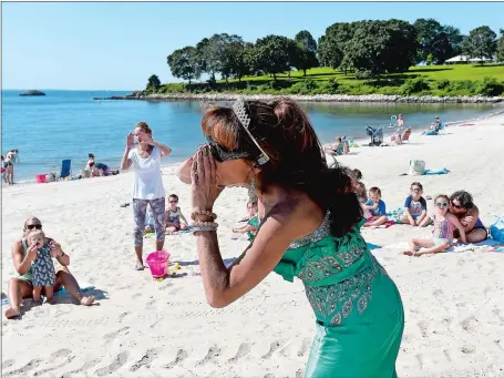  ?? SARAH GORDON/THE DAY ?? Dressed as a mermaid-princess, Rebecca Scotka, a children’s librarian at the East Lyme Public Library, sings a song during a storytime event at Hole-in-the-Wall Beach on Monday in Niantic. The event, which is held in partnershi­p with the Department of Parks and Recreation, has been held a few times a season for four summers. “It’s just so great to take advantage of our amazing town,” said Scotka, “and I won’t complain about working from the beach for a morning.”