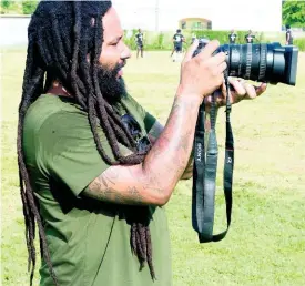  ??  ?? Ky-Mani Marley, owner of Falmouth United Football team, captures images of his team during a training session on Wednesday.