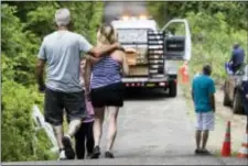  ?? MATT ROURKE — THE ASSOCIATED PRESS ?? People walk at the entrance to a blocked off drive way, in Solebury, Pa., as the search continues Wednesday for four missing young Pennsylvan­ia men feared to be the victims of foul play.