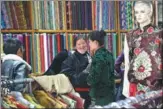  ?? DAQIONG / CHINA DAILY ?? Sonam Tsomo (center) shops for holiday outfits at a shop in Lhasa, Tibet autonomous region.