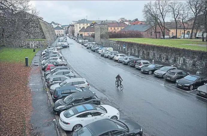  ?? FREDRIK BJERKNES / BLOOMBERG / ARXIU ?? Un ciclista travessa una estació de recàrrega de vehicles elèctrics a Oslo en una imatge del desembre de l’any passat