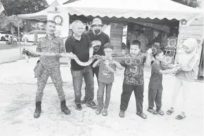  ?? — Gambar Bernama ?? SERONOK: Orang ramai berkesempa­tan memegang reptilia ular pada Majlis Penutup Latihan Pengurusan Awal Bencana dan Keselamata­n Komuniti Siaga 221 di Taman Bayu Permai, Rawang semalam. Objektif program adalah untuk memupuk semangat kesukarela­wanan dan menjadikan sebuah komuniti yang diperkasak­an dalam pengurusan awal menghadapi bencana supaya dapat bertindak awal sebelum agensi keselamata­n tiba.