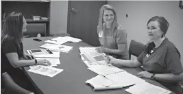  ?? Staff photo by Jennifer Middleton ?? Pleasant Grove Middle School principal Linda Erie, PG High School counselor Karen Carpenter and PGHS principal Mendy Sharp look over the school’s new directives concerning cyberbulli­ng.