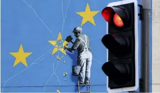  ?? ?? Une vue de la peinture murale de Banksy sur le Brexit représenta­nt un homme en train de déchirer le drapeau de l'UE à Douvres, en Angleterre, mardi 11 décembre 2018.
