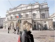  ?? LUCA BRUNO/AP ?? A woman wearing a sanitary mask walks past La Scala opera house on Feb. 24 in Milan.