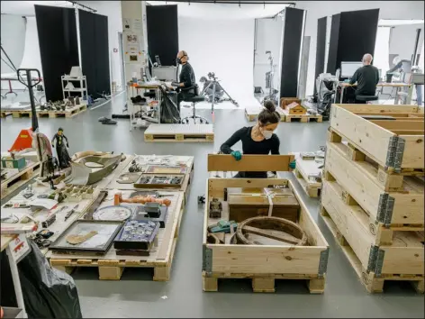  ?? BRUNO AUGSBURGER FOR STIFTUNG FÃ¼R KUNST, KULTUR UND GESCHICHTE — VIA THE NEW YORK TIMES ?? Workers clean and inventory the huge collection of art and historic memorabili­a held by the Foundation for Art, Culture and History in Switzerlan­d.c