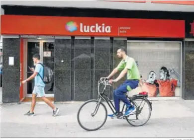  ?? JOSÉ ÁNGEL GARCÍOA ?? Dos jóvenes pasan por delante de una casa de apuestas de la capital.