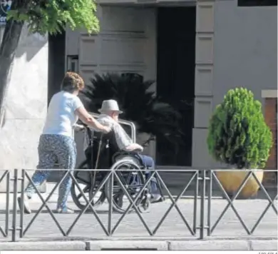  ?? JUAN AYALA ?? Una mujer empuja la silla de ruedas de un hombre mientras dan un paseo.