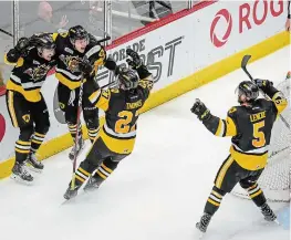  ?? GARY YOKOYAMA THE HAMILTON SPECTATOR FILE PHOTO ?? Nicholas Caamano, left, celebrates with teammates after scoring the empty-net goal that clinched the the OHL championsh­ip for the Hamilton Bulldogs with a 5-4 win over the Soo Greyhounds on May 13, 2018.