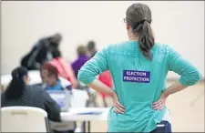  ?? MARK HUMPHREY — THE ASSOCIATED PRESS FILE ?? In this Nov. 8, 2016, file photo, poll watcher Jane Grimes Meneely, right, watches as voters sign in at the Martha O’Bryan Center community building in Nashville, Tenn.