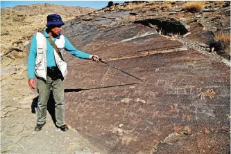  ??  ?? Iranian archeologi­st Mohammed Naserifard displays ancient engravings in the hills outside the town of Khomein in central Iran. — AFP photos