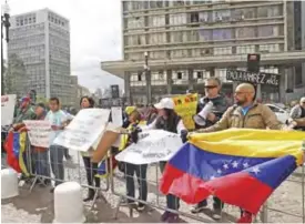  ??  ?? SAO PAULO: Venezuelan citizens living in Brazil protest against Venezuelan President Nicolas Maduro, outside Sao Paulo’s City Hall as the Foreign Ministers of Mercosur meet in Sao Paulo. The South American trade bloc has decided to suspend Venezuela...