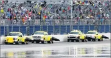  ?? By Douglas Jones, US Presswire ?? Futile effort: Track workers use jet dryers Sunday on the backstretc­h at Daytona Internatio­nal Speedway. Rain kept falling, postponing the race.