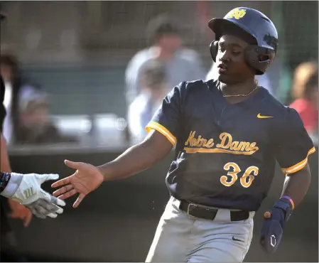  ?? PHOTO BY ANDY HOLZMAN ?? Notre Dame's Dean West scores a run against Harvard-Westlake during Friday's Mission League game. Notre Dame went on to a 9-4victory.