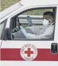  ??  ?? 0 Italian Red Cross workers are wearing respirator­y masks